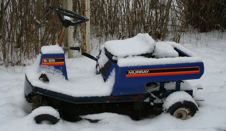 Aufsitzmäher sollte man im Winter nicht einfach wie hier im Schnee stehen lassen. Besser ist es, den Rasentraktor winterfest zu machen und fachgerecht einzuwintern.
