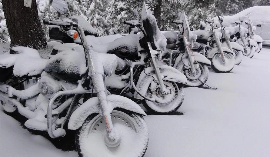 Snow-covered motorbike at the side of the road: Not the best way to winter your motorbike. It is better to store it dry and clean and remove or at least disconnect the battery.