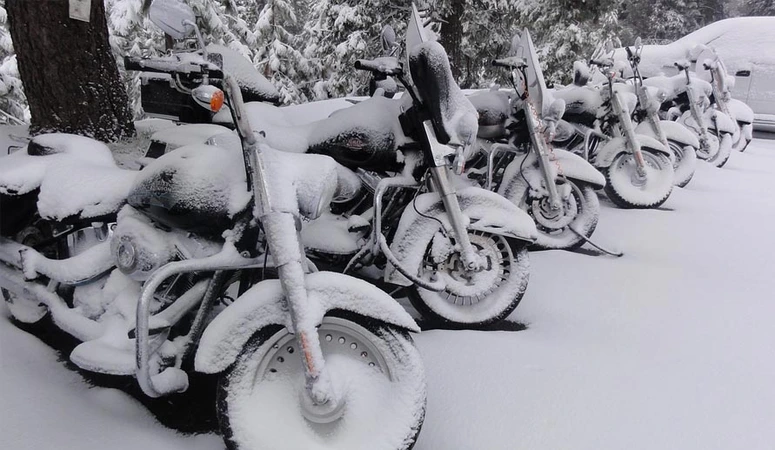 Snow-covered motorbike at the side of the road: Not the best way to winter your motorbike. It is better to store it dry and clean and remove or at least disconnect the battery.
