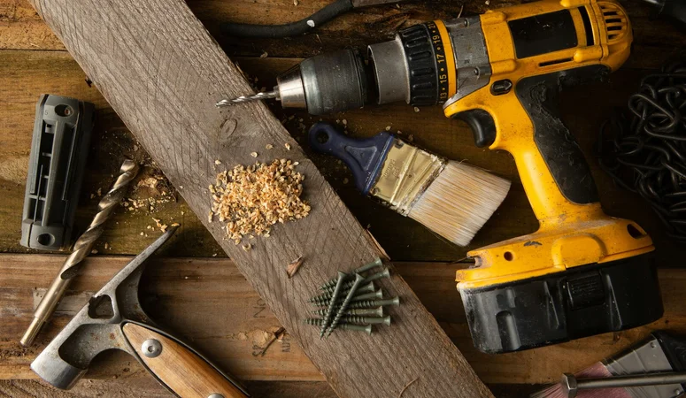 Yellow cordless screwdriver with other tools on a construction site