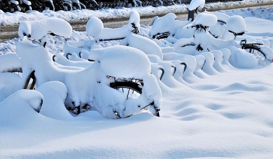 Snow-covered bikes. The battery should be removed from e-bikes in winter.