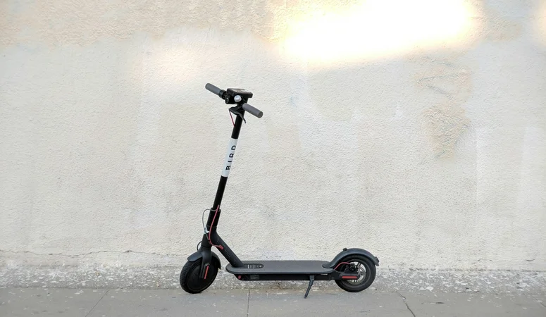 Schwarzer E-Scooter vor beiger Wand. Viele fragen sich, wie und wo man E-Roller aufladen kann.