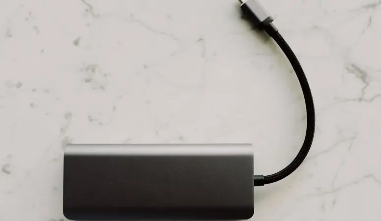 Schwarze Powerbank mit Kabel: Bis 100 Wh bzw. 27.000 mAh darf sie im Handgepäck ins Flugzeug mitgenommen werden.